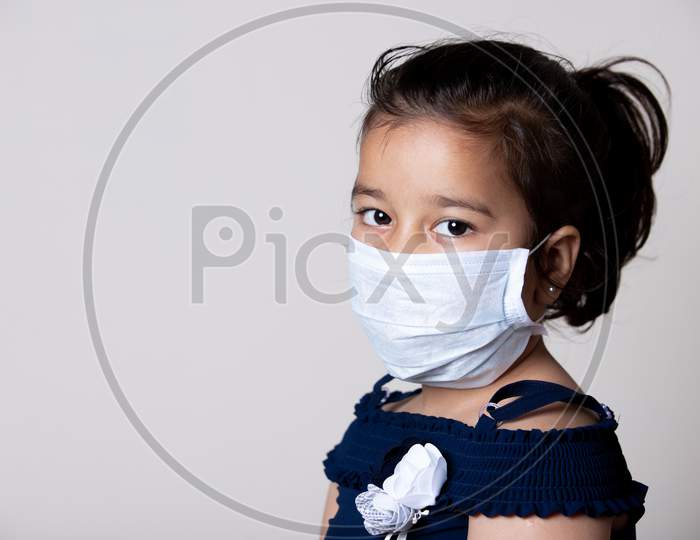 Indian Girl Child Face Covered With Mask At Home To Prevent From The Spread Of Corona Virus Infection.