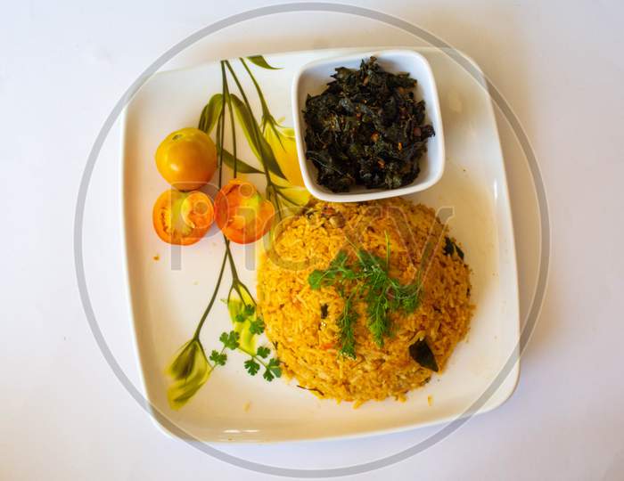 Healthy nutritious plate of Greek tomato rice or pilaf topped with fresh chopped coriander and served on a rustic earthenware plate