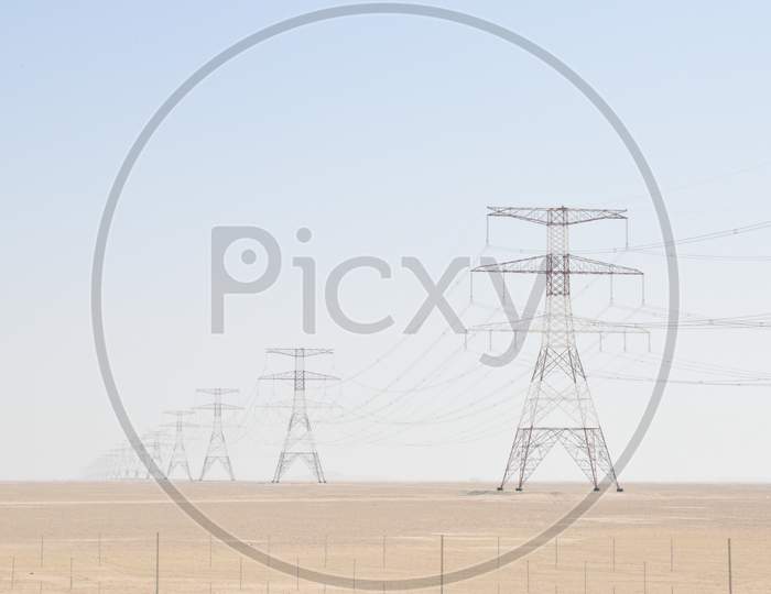 Electric Post Is Used To Support High Voltage Powerhead Lines.Electric Tower In Desert. At Liwa,Abu Dhabi