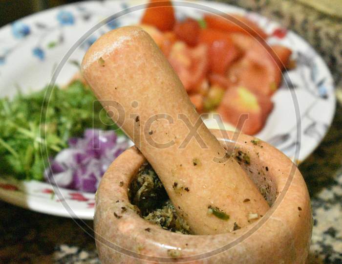 Traditional Wooden Mortar And Tomato,Vegetable In The Background.