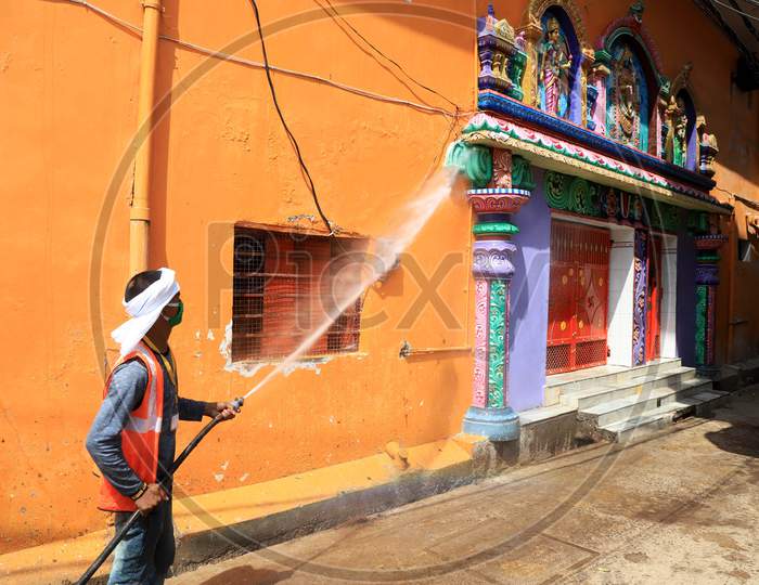A worker of municipality sanitizes a temple during a government-imposed nationwide lockdown as a preventive measure against Coronavirus,  in Prayagraj, May 3, 2020.