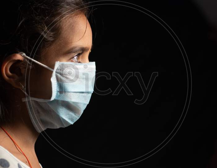 Young Teenager Girl With Medical Face Mask In Dark Room At Home Quarantine Due To Covid 19 Or Coronavirus Outbreak - Concept Of Hope And Fight To End Virus Crisis.