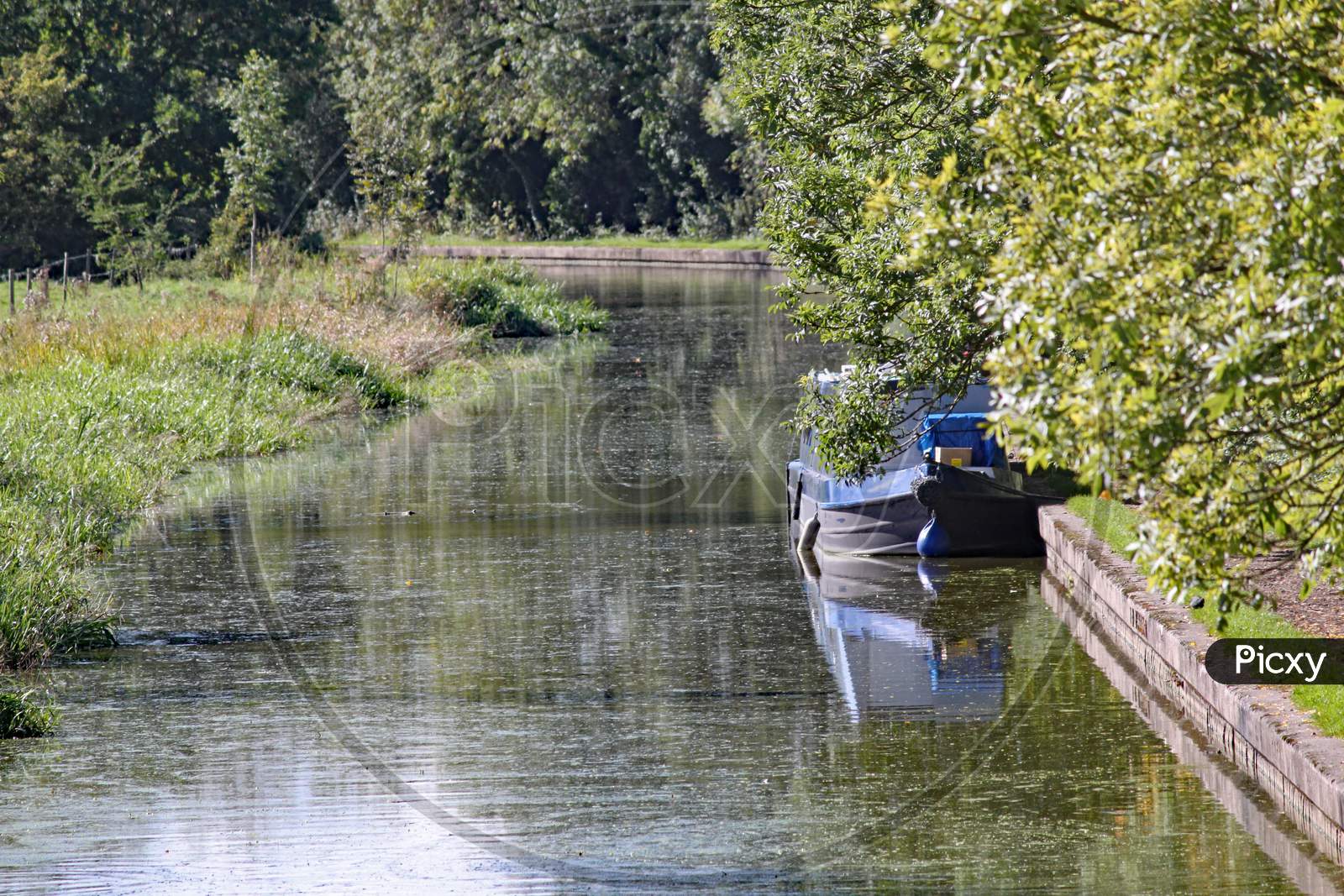 A Barge Moored To The Bank On The Grand Union Canal At Lapworth In Warwickshire, England
