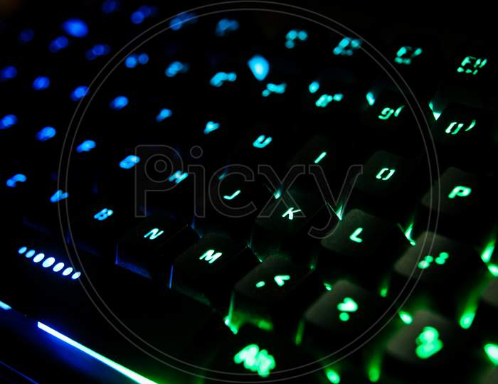 Gaming keyboard with RGB lighting for desktop computer, switches of keyboard are glowing with colorful back lights