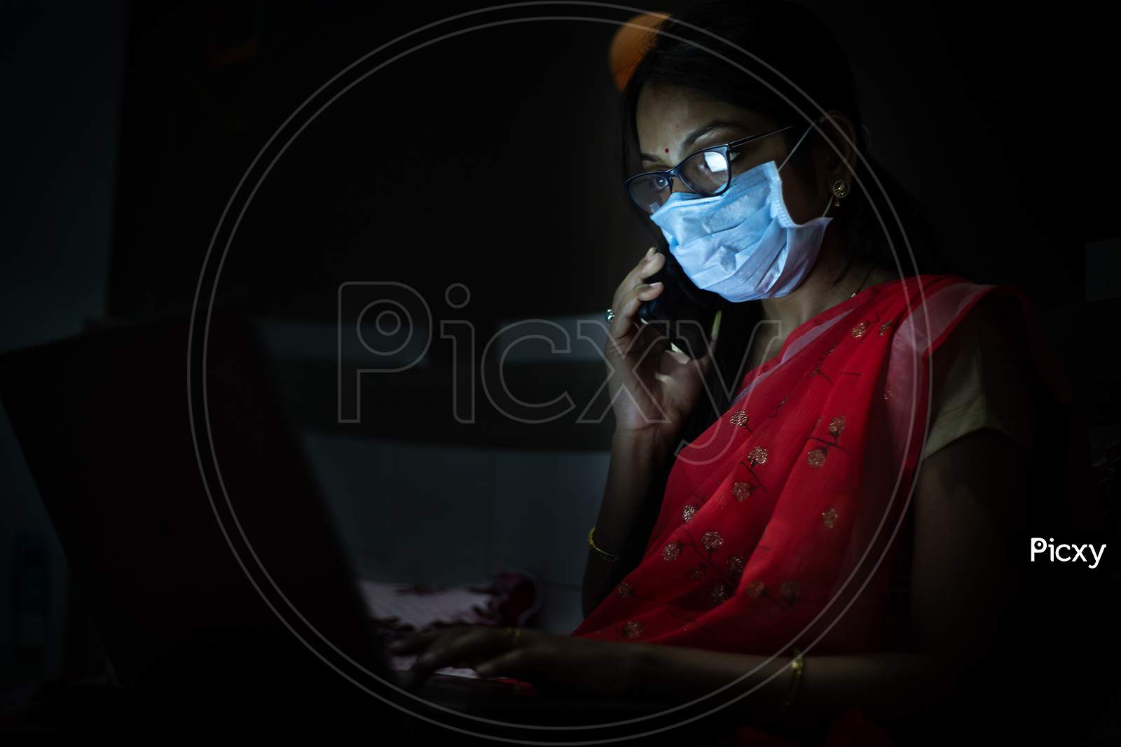 Young Indian Woman Wearing Mask Working On Her Laptop Late Night, Freelancer Working From Home. Coronavirus,Covid-19. Stay Home Stay Safe, Woman In Quarantine.