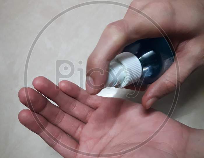 Sanitizing The Hands With Hand Sanitizer to avoid the spread of  covid 19 or coronavirus on A White Background