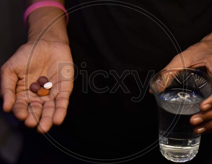 corona antivirus tablets in a boy hand on black background