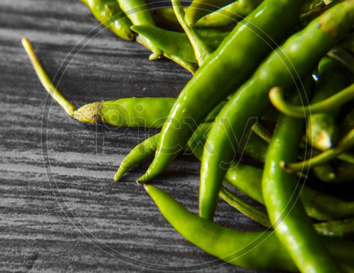 Bunch of green chilies on table , Close up photo of green chili, Spicy green chilies for daily purpose usage in food