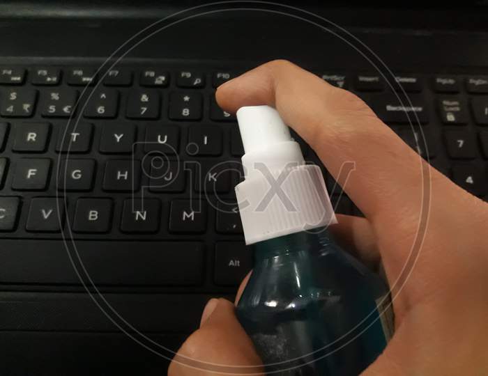 Sanitizing The Keyboard Of Laptop With Sanitizer
