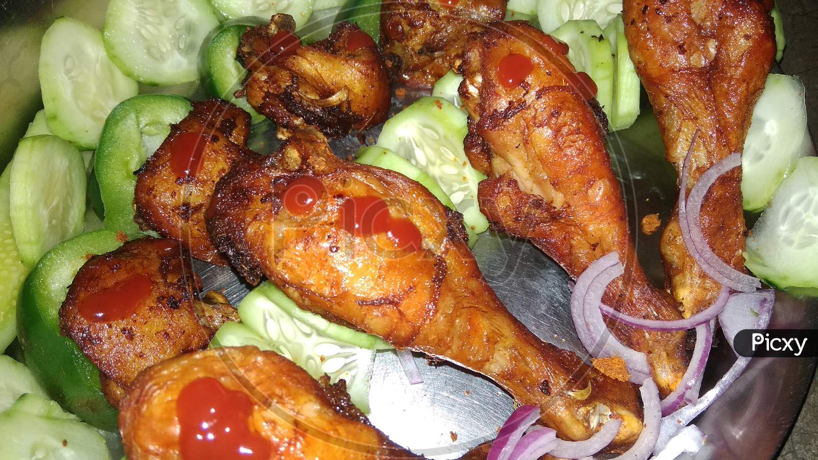 Fried Tandoori chiken in a plate with salad and sause