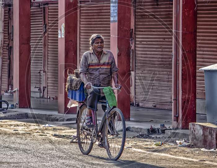 october 2018, babu bazaar, jaipur rajasthan india: A man.carrying a weight on his bicycle
