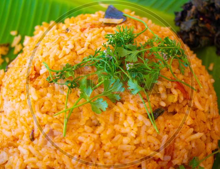 Healthy nutritious plate of Greek tomato rice or pilaf topped with fresh chopped coriander and served on a rustic earthenware plate
