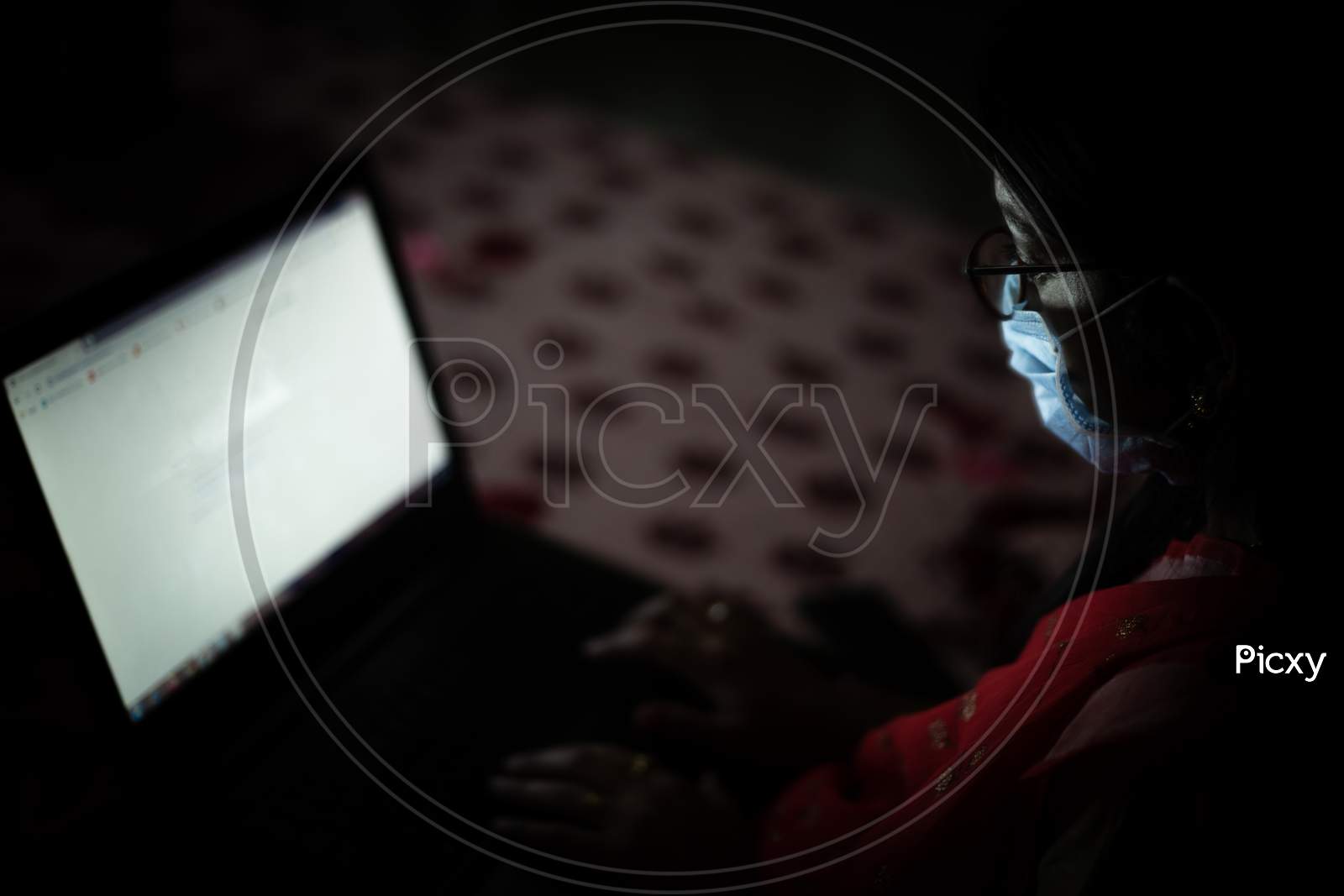 Young Indian Woman Wearing Mask Working On Her Laptop And Talking On Phone, Late Night Working, Freelancer Working From Home. Coronavirus,Covid-19. Stay Home Stay Safe, Woman In Quarantine.