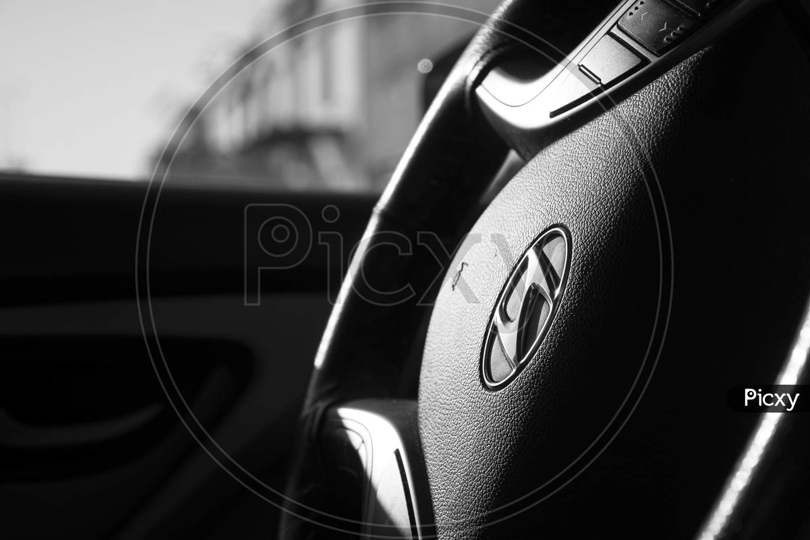 4th May 2020 Muscat, Oman: Black and white sedan car steering wheel during daytime with blur background, Car interior concept.