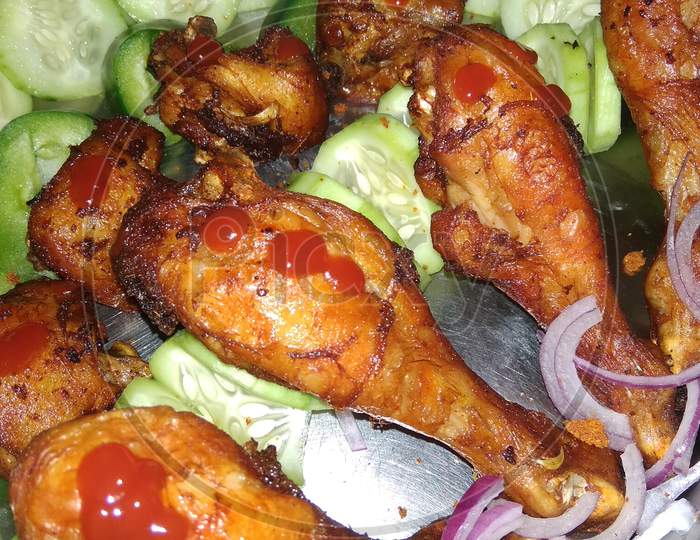 Fried Tandoori chiken in a plate with salad and sause