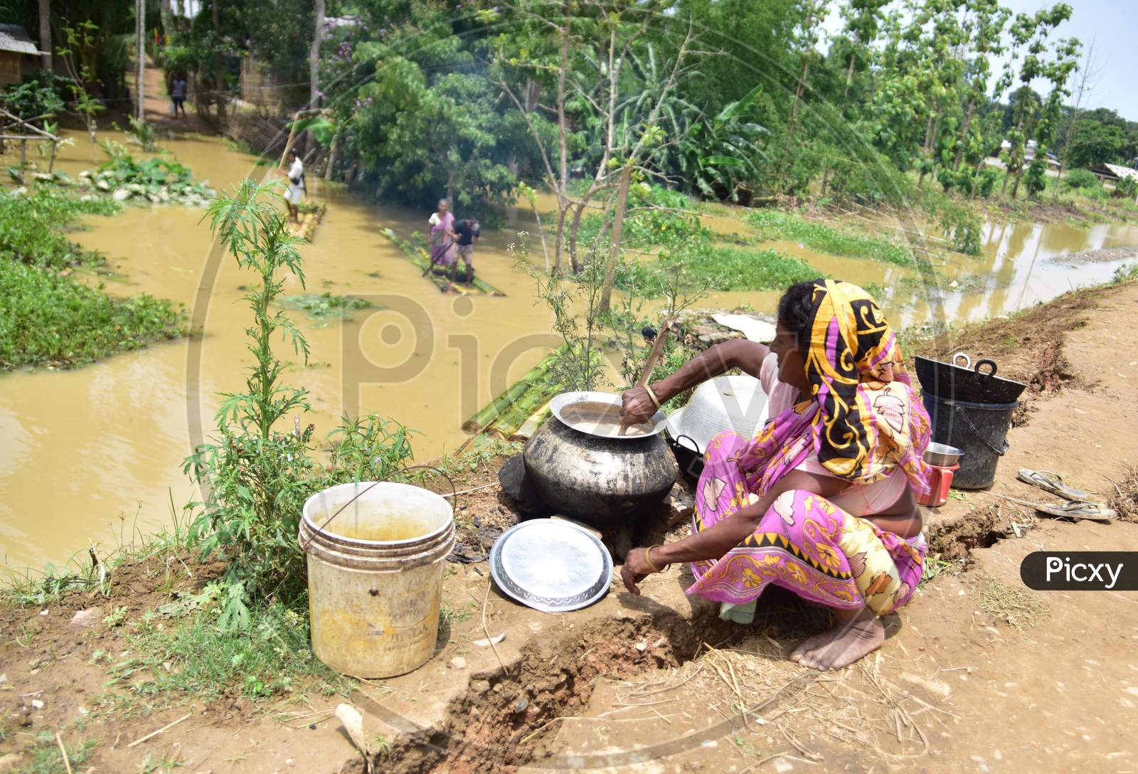 A  Flood Affected Woman Cooks On A  Road  In Hojai District Of Assam On May 30,2020.
