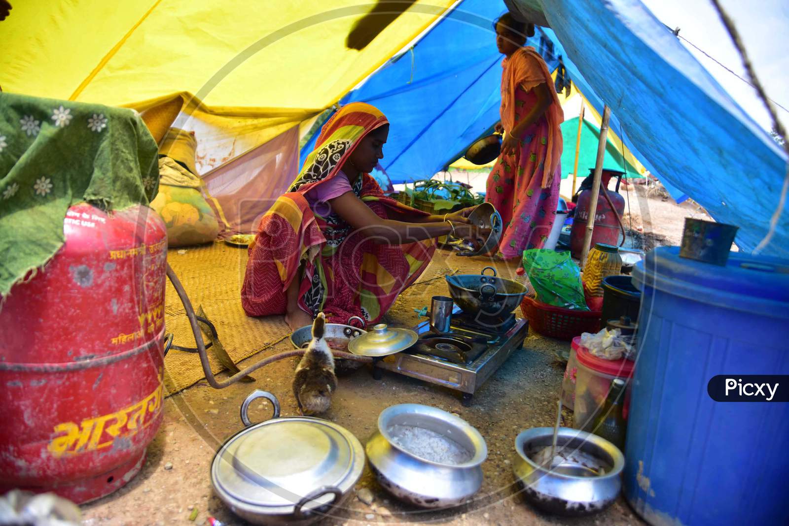A  Flood Affected Woman Cooks Inside Her Makeshift Shelter On A Railway Track In Hojai District Of Assam On May 30,2020.