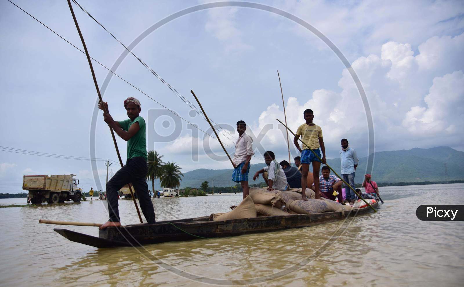 People Transport Sacks Of Rice Through A Boat At A Flooded Village In Hojai District Of Assam On May 30,2020.