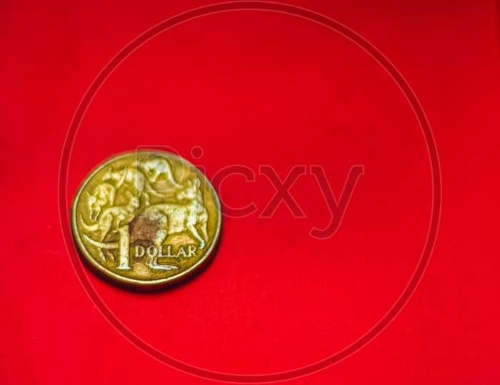 Australian Dollar Coin Front Isolated On Red Background With Soft Blurry And Space For Copy Text. One Dollar Coin 1995 Australian Currency. Old Coins Collections Worldwide.