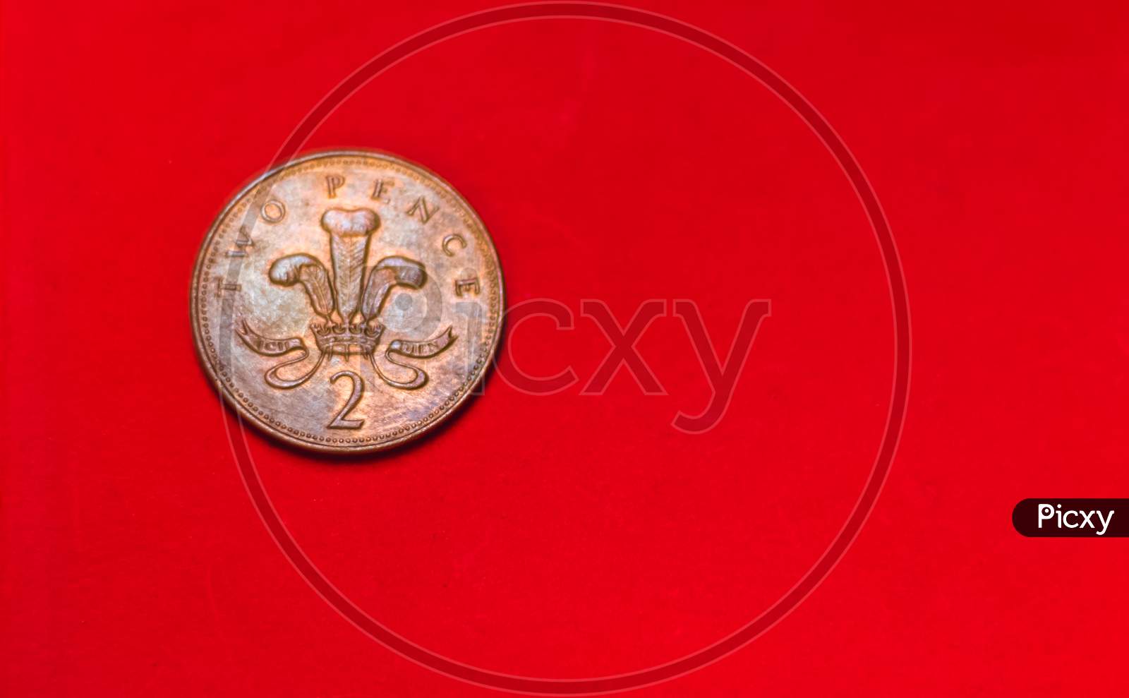 British Coin 2 Pence (2001) Isolated On Red Background With Blurry And Space For Copy Text. Front Side Of Two Pence Coin. Coins Collectors Wolrdwide.