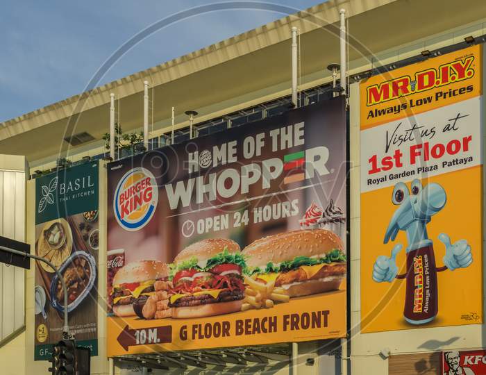 Pattaya,Thailand - April 10,2019:Beachroad This Is The Exterior Of The Medium-Sized,Old Shopping Mall Royal Garden Plaza.It Shows Ads For Fast Food Restaurants And A New Shop For Craftsmen.