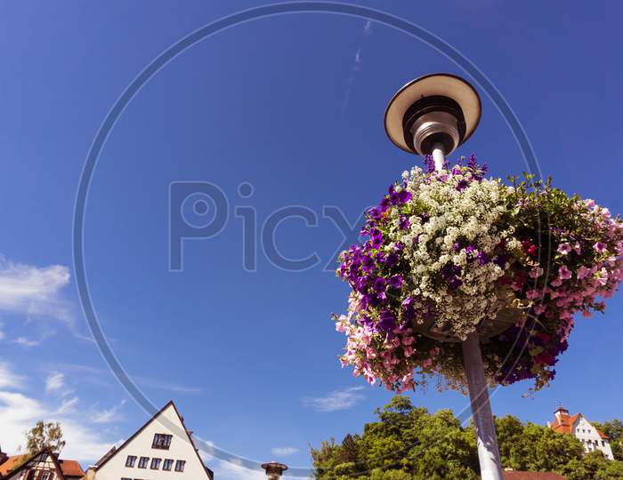 A Bunch Of Colorful Flowers On A Lamp Post