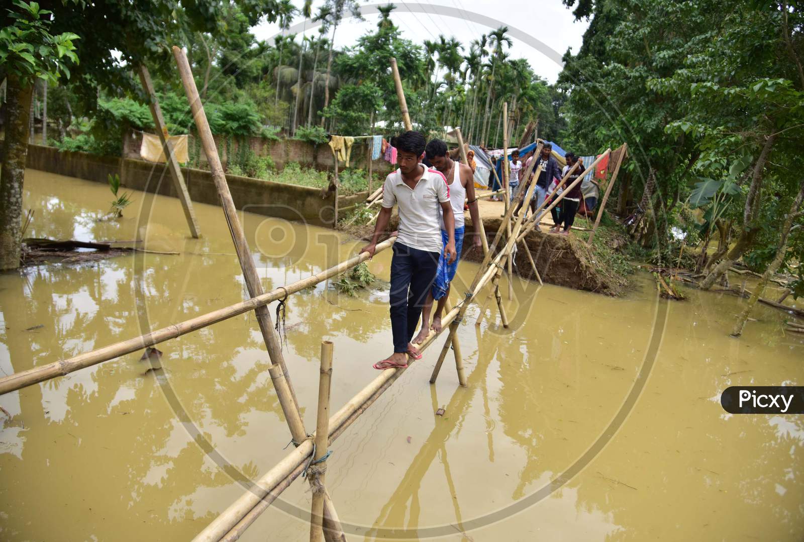 Villagers Use A Makeshift Bamboo Bridge After A Road Washed Out By Flood Water In Hojai District Of Assam On May 30,2020.