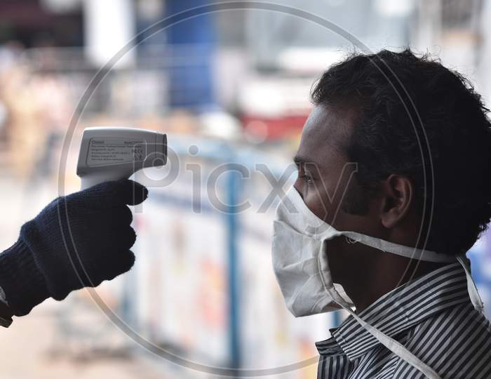 An APSRTC Worker Conducts Thermal Screening Of A Passenger Before Boarding A Bus, At Pandit Nehru Bus Station, During The Ongoing Coronavirus Lockdown, In Vijayawada.