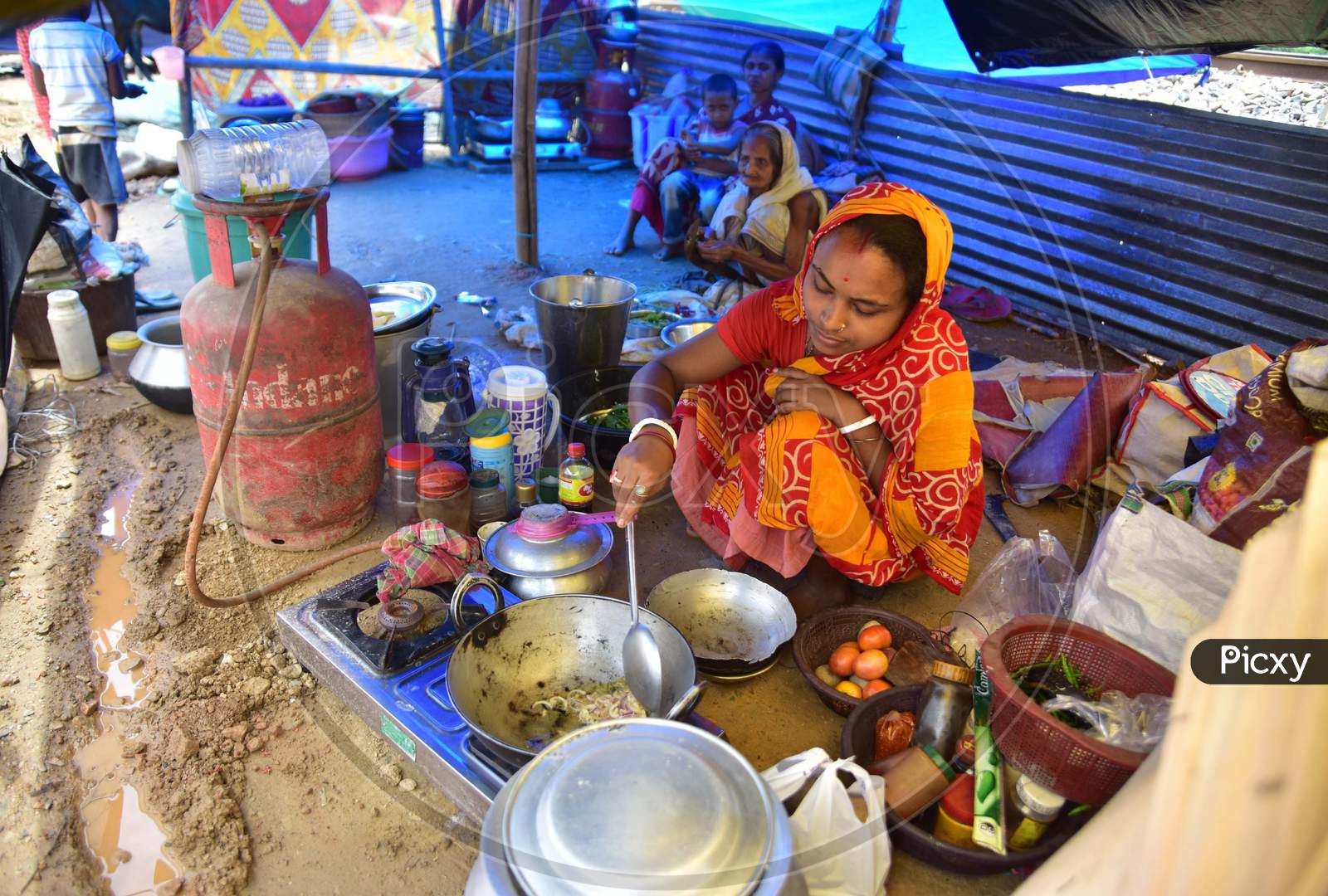 A  Flood Affected Woman Cooks Inside Her Makeshift Shelter On A Near A Railway Track In Hojai District Of Assam On May 30,2020