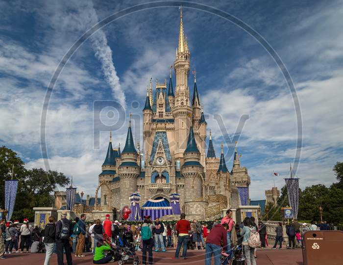 Cinderella's castle in Magic kingdom  Orlando, Florida with people in foreground and clouds in sky in background