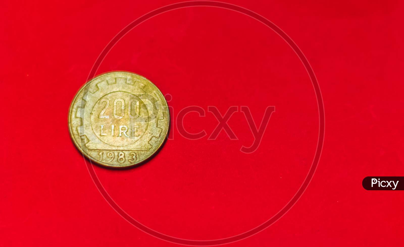Italian 200 Lire Coin.Front Side Of Old Used Two Hundred Italian Lire, 1983. Vintage Bronze Coin Isolated On Red Background With Space For Text Copy. Repvbblica Italiana 200