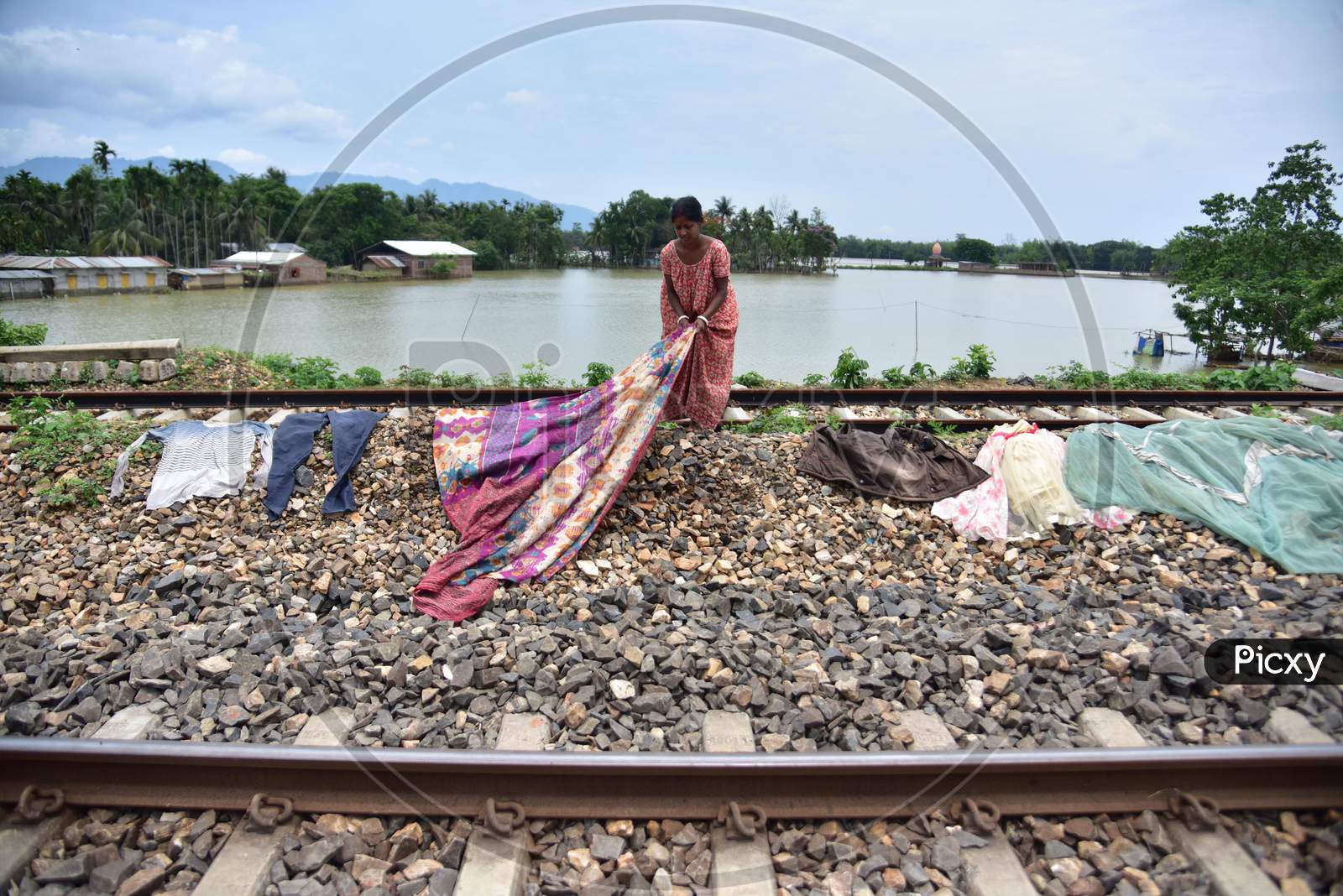 A Flood Affected Woman Dries Her Clothes Near A Railway Track  In Hojai District of Assam On May 30,2020.