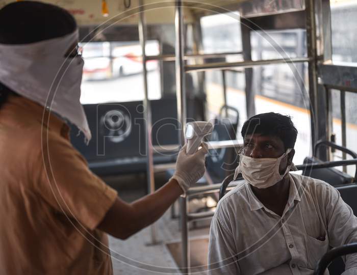 An APSRTC Worker Conducts Thermal Screening Of A Passenger Inside A Bus, At Pandit Nehru Bus Station, During The Ongoing Coronavirus Lockdown, In Vijayawada.