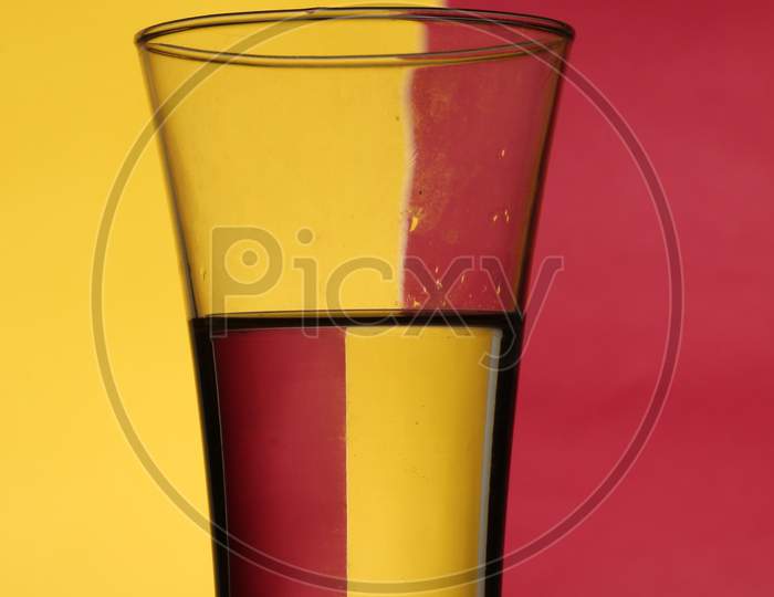 the glass of water with red and yellow background
