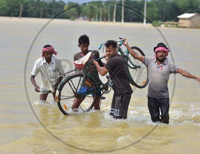 Villager Carry a Bicycle As they Wades Through A Flooded Road In Hojai District Of Assam On May 30,2020.