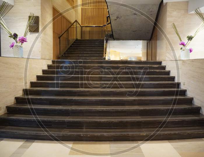 Chandigarh, India - November 2019: Luxurious Staircase With Marble Steps And Decorative And Ornamental Iron And Glass Railings. Elegant Historical Stairs In A Luxury Interior Inside A Hotel.