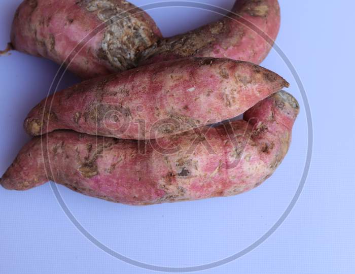 Fresh sweet potato with root at farmer market as a food background