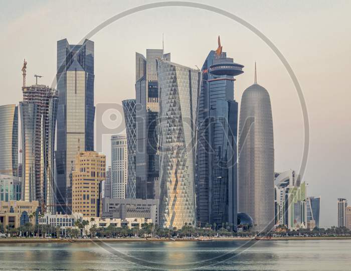 Doha Qatar skyline sunset view showing financial district in West Bay with modern skyscrapers and clouds in the sky.