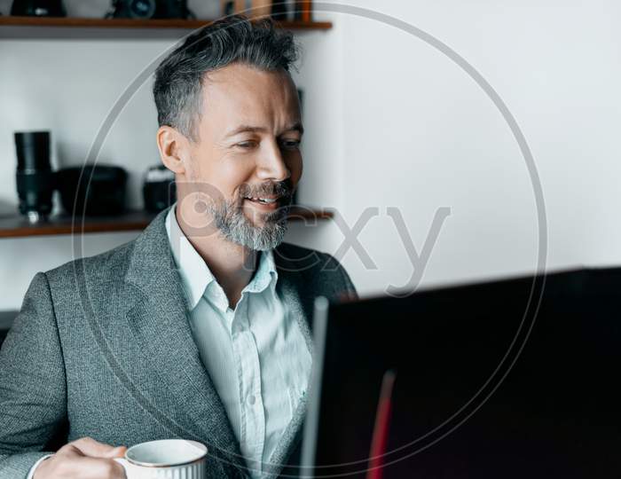 Portait of happy businessman working on his computer