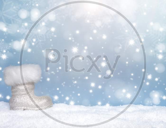 Winter Seasonal Background With The Boot Of Santa And Snow And Snow Flakes