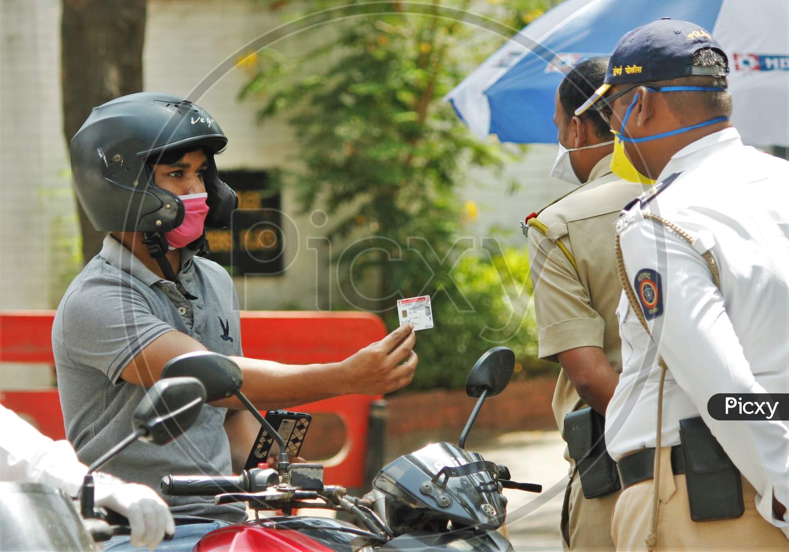 Police personnel ask for IDs and documents from the people coming out during a 21- day nationwide lockdown to limit the spreading of coronavirus disease (COVID-19) in Mumbai, India, on April 10, 2020.