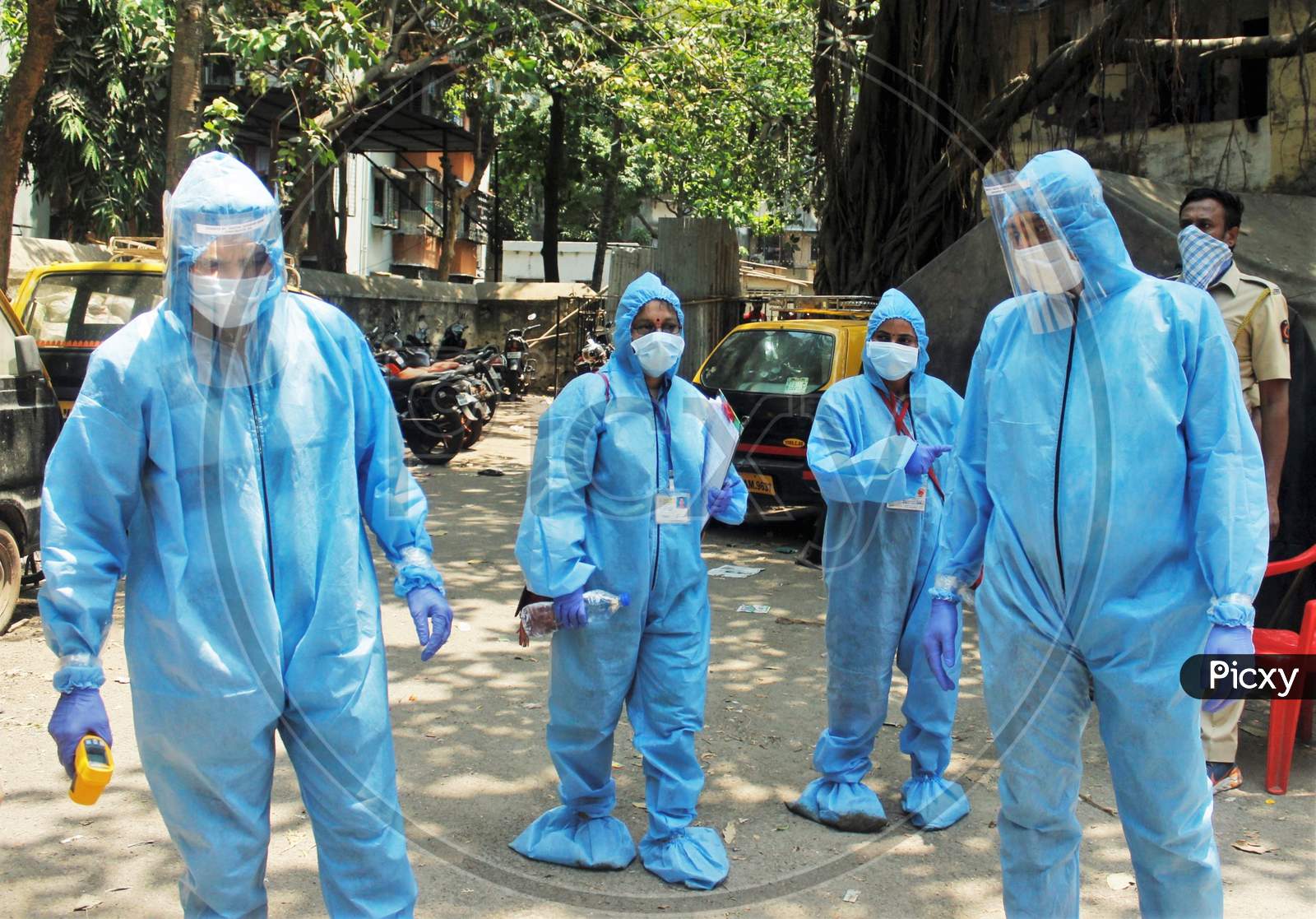 Doctors wearing protective suits arrive at spot to scan the residents of  Dharavi, one of Asia's largest slums, with an infrared thermometer to check their temperature as a precautionary measure against the spread of the coronavirus disease (COVID-19), in Mumbai, India, April 12, 2020.