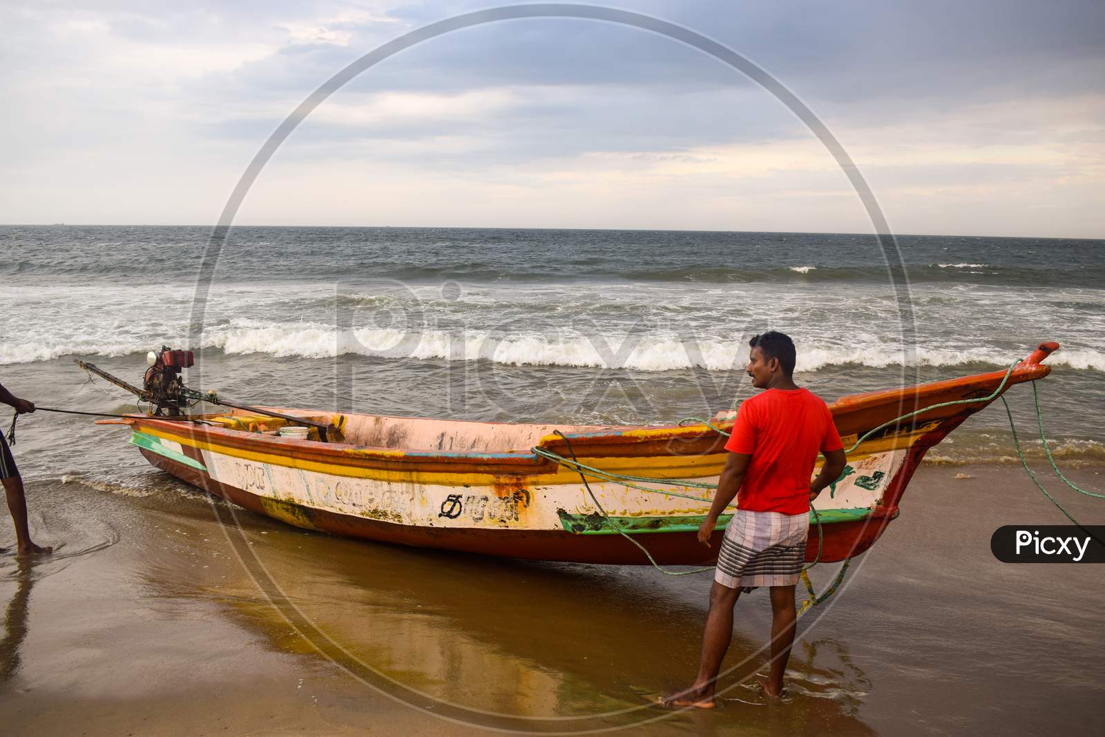 Pondicherry, Puducherry, Karnataka, 2019 : Fisherman pulling their boat out of water and cancelling their plan of fishing after high tide alert