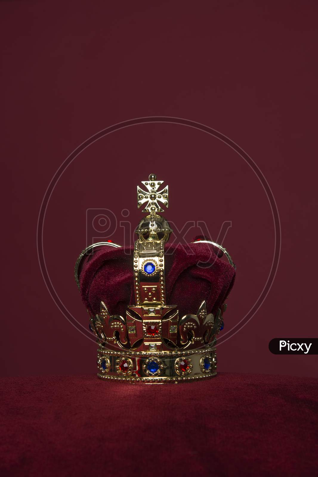 Golden Crown On A Velvet Cushion On A Deep Red Background With Copy Space In A Vertical Image