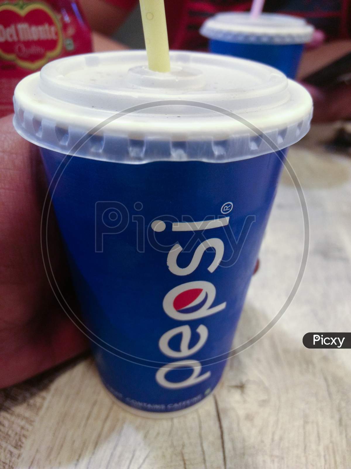 India, Delhi -June 5,2019 : Paper Glasses Of Pepsi Soft Drink In Hand On Wooden Table At Food Court