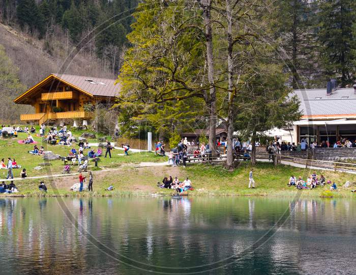 Interlaken, Switzerland,2019 : People enjoying near a lake during summers.  A picturesque scene of Lake Blausee in Switzerland which is a famous picnic spot for locals.