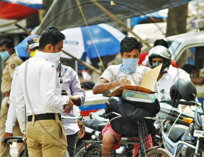 Police personnel ask for IDs and documents from the people coming out during a 21- day nationwide lockdown to limit the spreading of coronavirus disease (COVID-19) in Mumbai, India, on April 10, 2020.