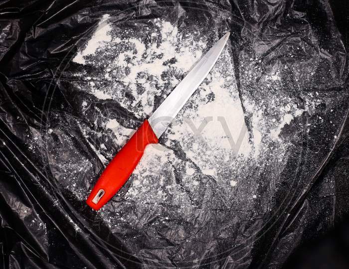 Red color knife in creative dark background