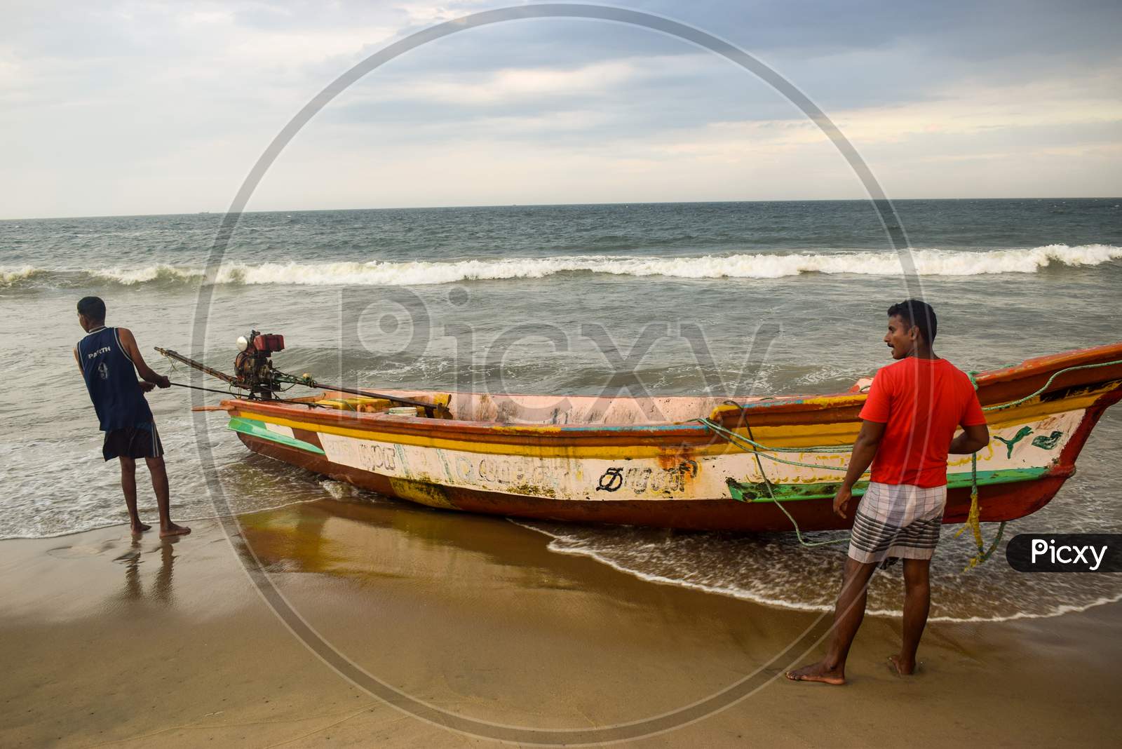 Pondicherry, Puducherry, Karnataka, 2019 : Fisherman pulling their boat out of water and cancelling their plan of fishing after high tide alert