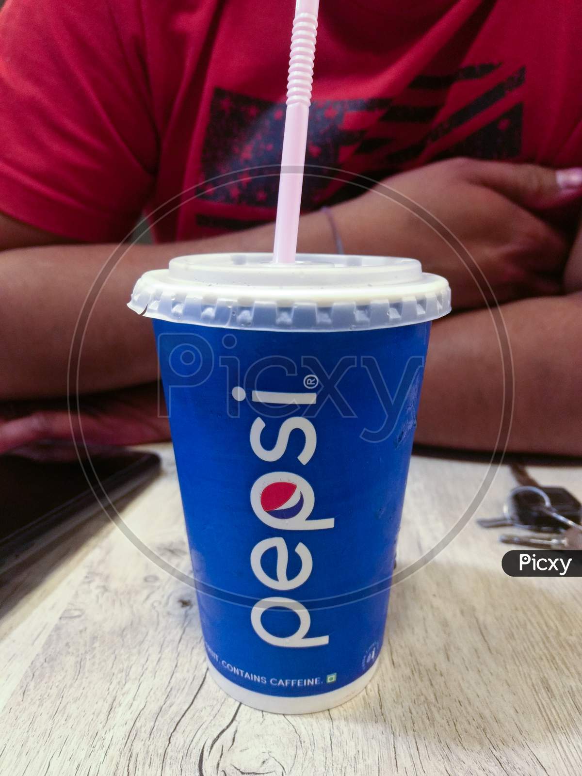 India, Delhi -June 5,2019 : Paper Glasses Of Pepsi Soft Drink In Hand On Wooden Table At Food Court